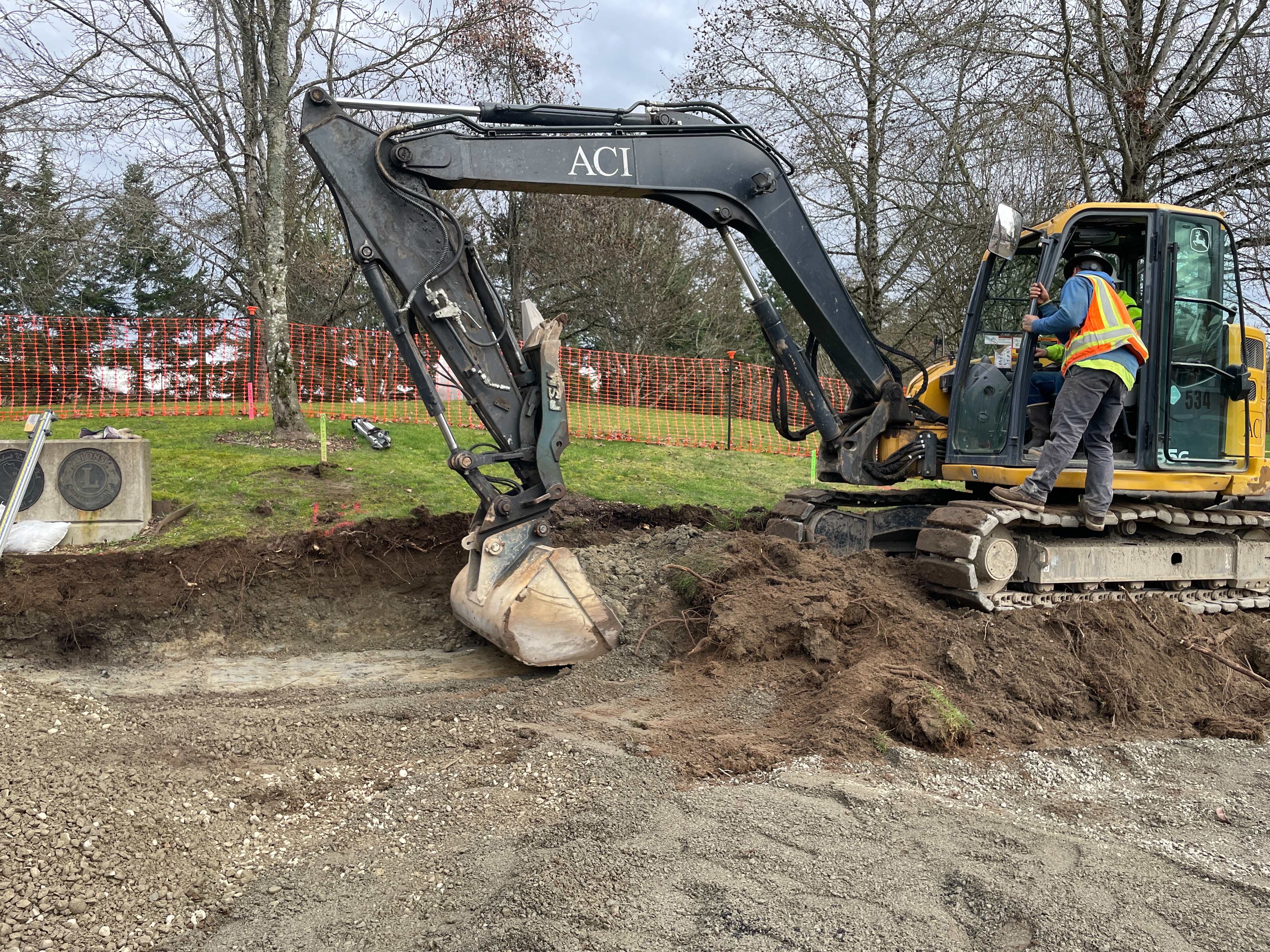 Excavator preparing site for sidewalk and asphalt path installation. 