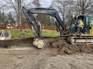 Excavator preparing site for sidewalk and asphalt path installation. 