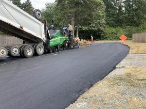 Placing the final lift of paving around the island at the intersection of SE 66th Street and 84th Ave SE.