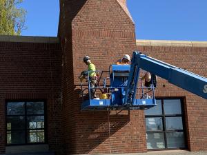 Masonry repair crew on lift