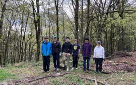 A group of volunteers standing in front of a forest. 
