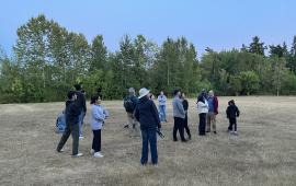 A group of people standing looking upwards in the sky,