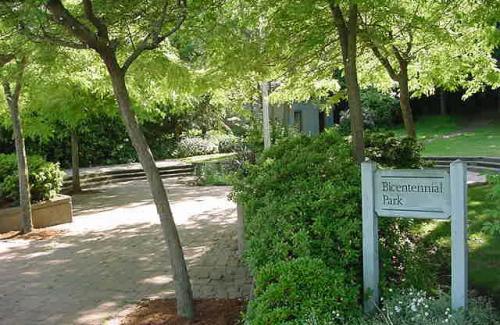 A small city park with a flagpole and paved plaza
