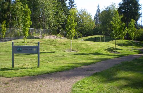 A community park featuring rolling green landscaping and a gravel pathway