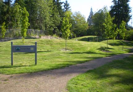 A community park featuring rolling green landscaping and a gravel pathway