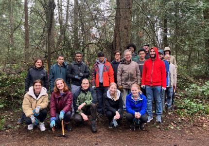A group of people posing in front of a forest