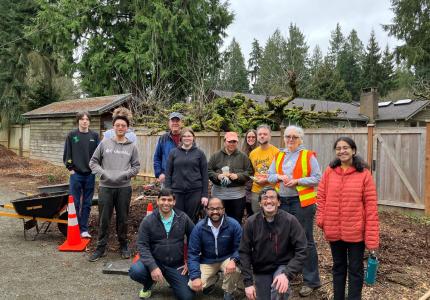 A group of smiling volunteers posing on a trail. 