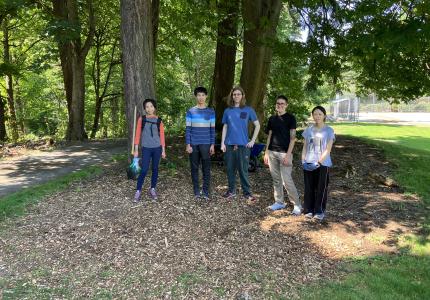 Volunteers posing in front of a stand of trees. 