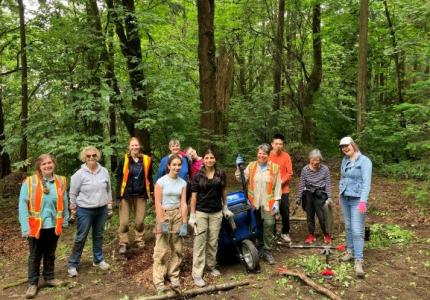 A group of volunteers posing in front of a forest