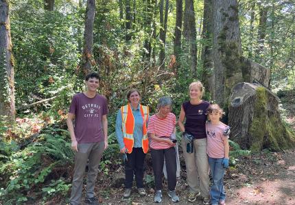 Volunteers posing in front of a forest. 
