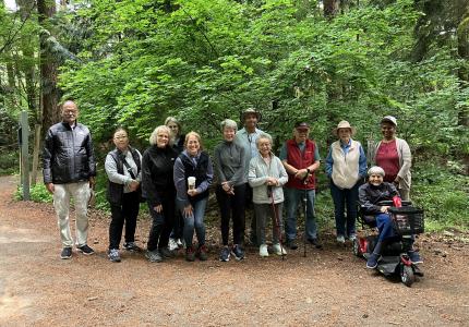 A group of people standing in the woods smiling.