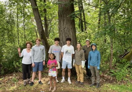 A group of volunteers pose in front of some trees