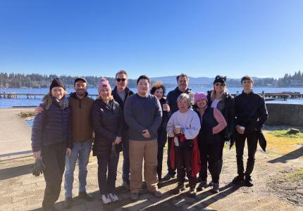 A group of volunteers posing in front of a blue sky.