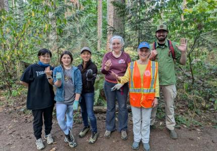 A group of volunteers posing a forest. 