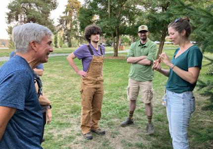 Volunteers learning about a douglas fir cone. 
