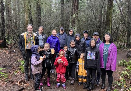 A group of volunteers posing in the forest on a rainy day. 