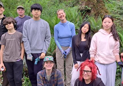 A group of volunteers posing in the woods.