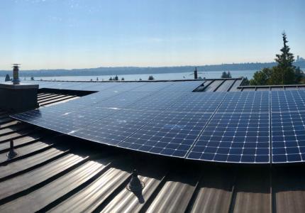 Image of a rooftop solar panel with Lake Washington on the horizon