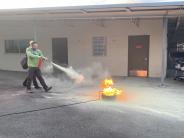 Two CERT participants safely use a fire extinguisher to put out small fire. 