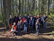 A large group of volunteers posing in the woods. 