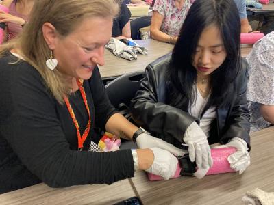 Two class participants apply tourniquet to form. 