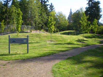 A community park featuring rolling green landscaping and a gravel pathway