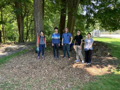 Volunteers posing in front of a stand of trees. 