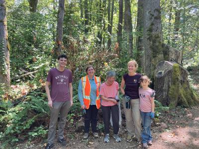 Volunteers posing in front of a forest. 