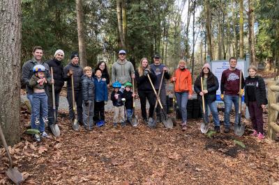 A group of people smiling and holding shovels.