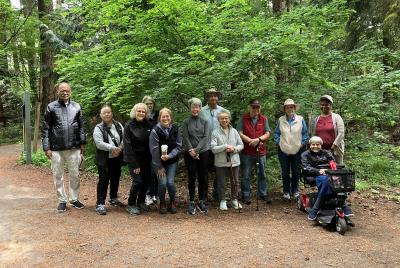 A group of people standing in the woods smiling.