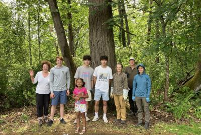A group of volunteers pose in front of some trees