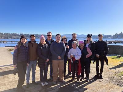 A group of volunteers posing in front of a blue sky.