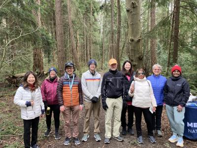 A group of people smiling and posing in front of a forest