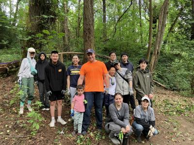 A group of volunteers posing in front of a forest