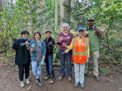 A group of volunteers posing a forest. 