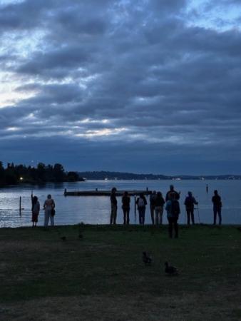 silhouette of people standing in front of a lake. 
