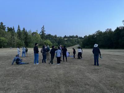 A group of people standing in a field looking up at the sky