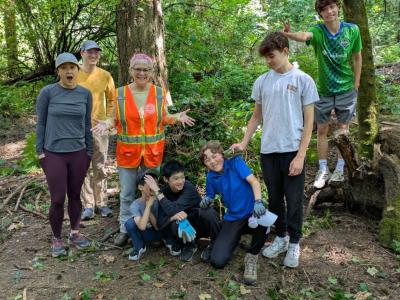 A group of volunteers posing in front of a forest. 