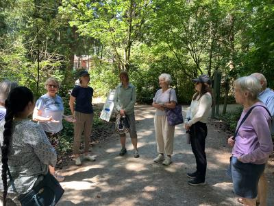 A group of participants standing in a circle in the woods. 