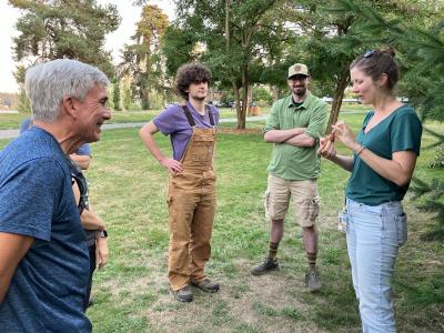 Volunteers learning about a douglas fir cone. 