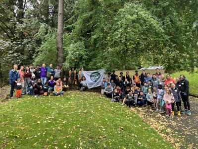 A large group of volunteers posing with an Arbor Day Flag