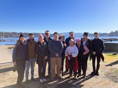 A group of volunteers posing in front of a lake with a blue sky!
