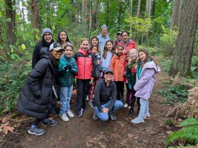 A group of volunteers posing in front of the forest.