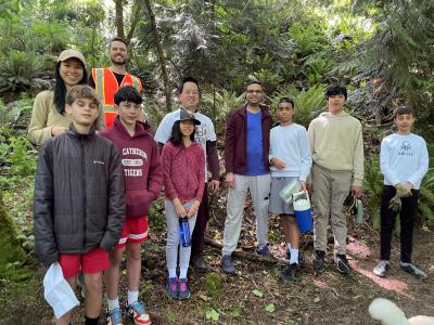 A group of volunteers posing in front of the forest.
