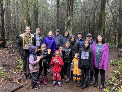 A group of volunteers posing in the forest on a rainy day.