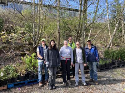 A group of volunteers posing in front of potted plants. 