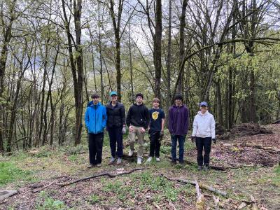 A group of volunteers standing in front of a forest. 