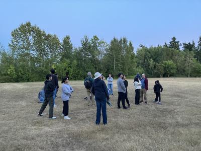 A group of people standing looking upwards in the sky, 