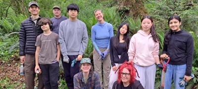 A group of volunteers posing in the woods.