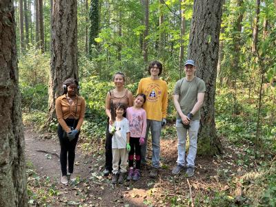 A group of volunteers standing in the forest on a sunny day. 
